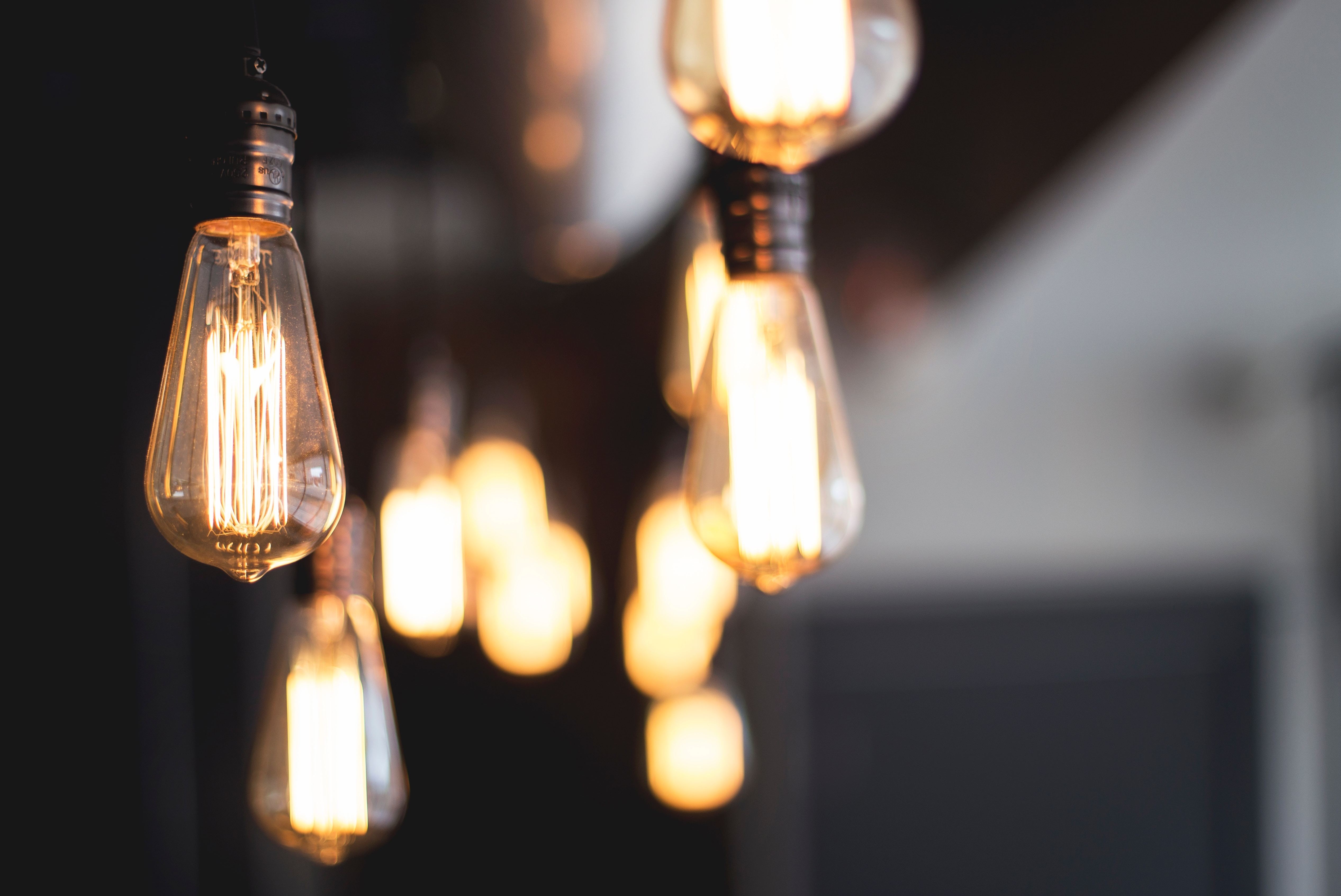 wide-selective-closeup-shot-illuminated-light-bulbs-hanging-from-ceiling